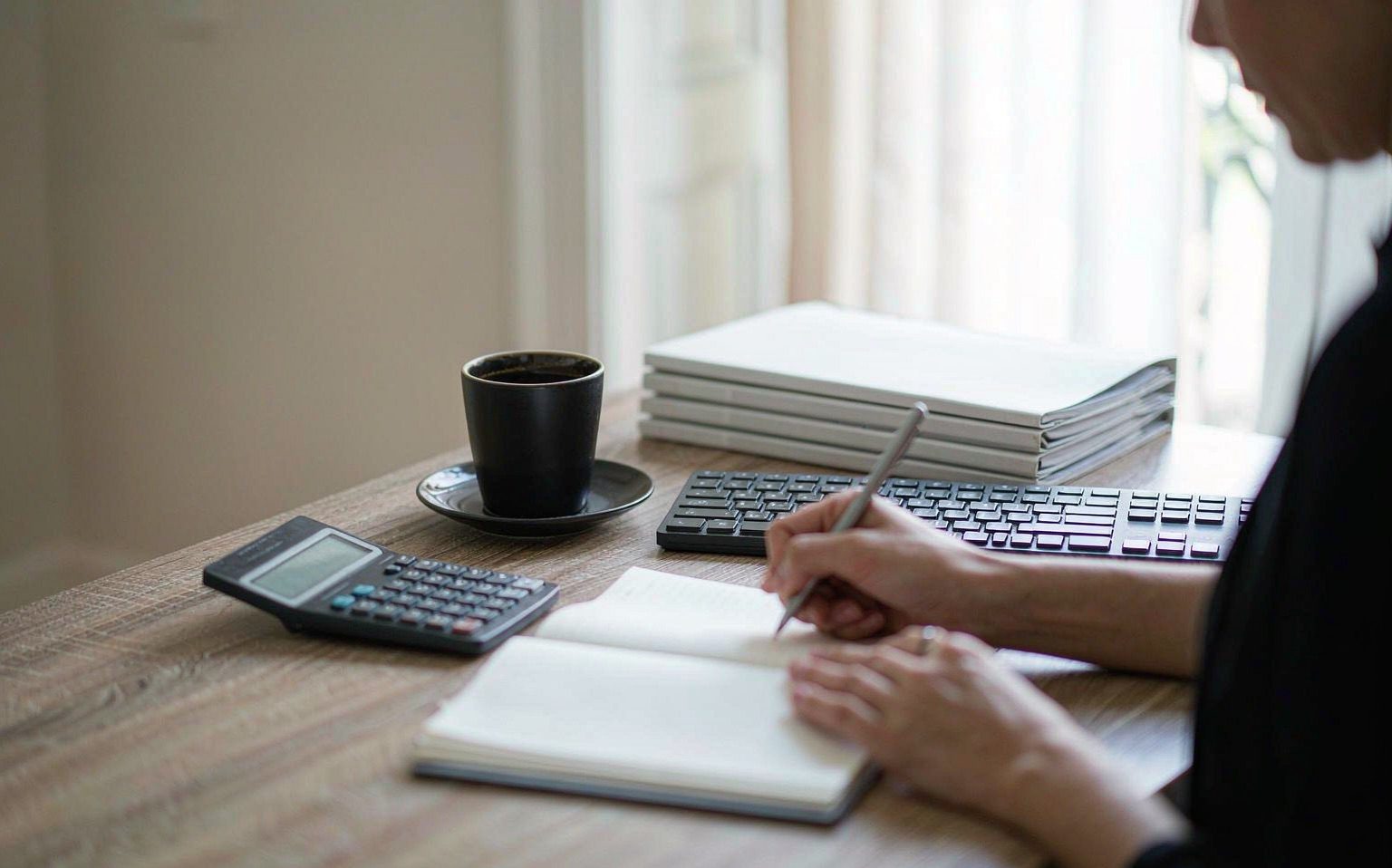 Escritorio de trabajo contable con calculadora, libreta y carpetas